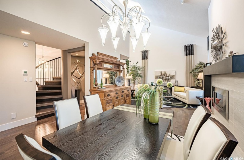 Dining area with a chandelier, a tile fireplace, dark hardwood / wood-style flooring, and a towering ceiling