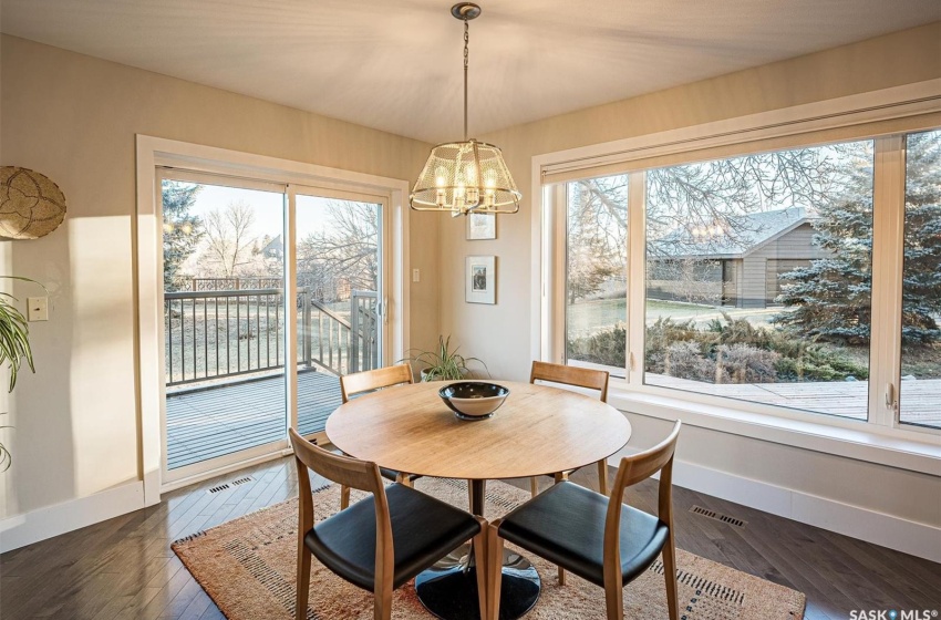 Kitchen Nook overlooking backyard with dark hardwood / wood-style flooring, a wealth of natural light, and a chandelier