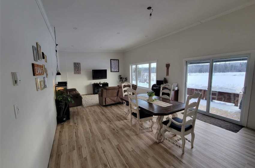 Dining area with ornamental molding and light hardwood / wood-style flooring