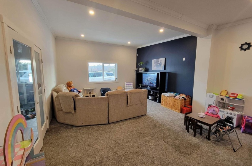 Carpeted living room featuring crown molding