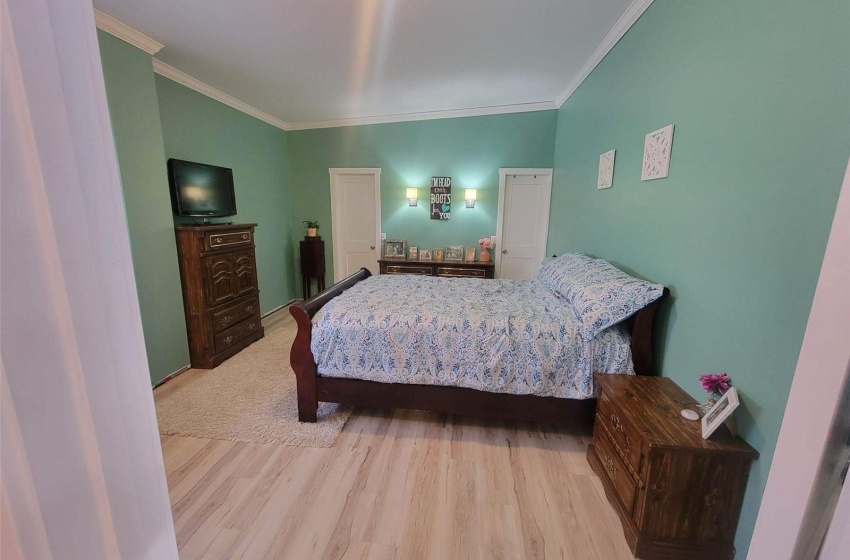 Bedroom with crown molding and light hardwood / wood-style flooring