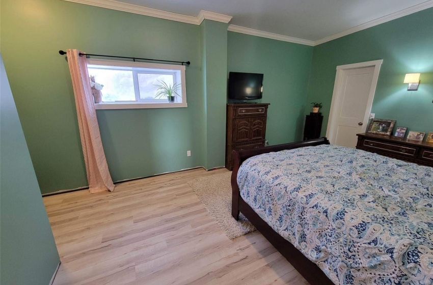 Bedroom featuring ornamental molding and light hardwood / wood-style flooring