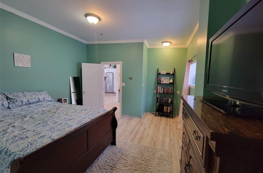 Bedroom with crown molding and light hardwood / wood-style floors