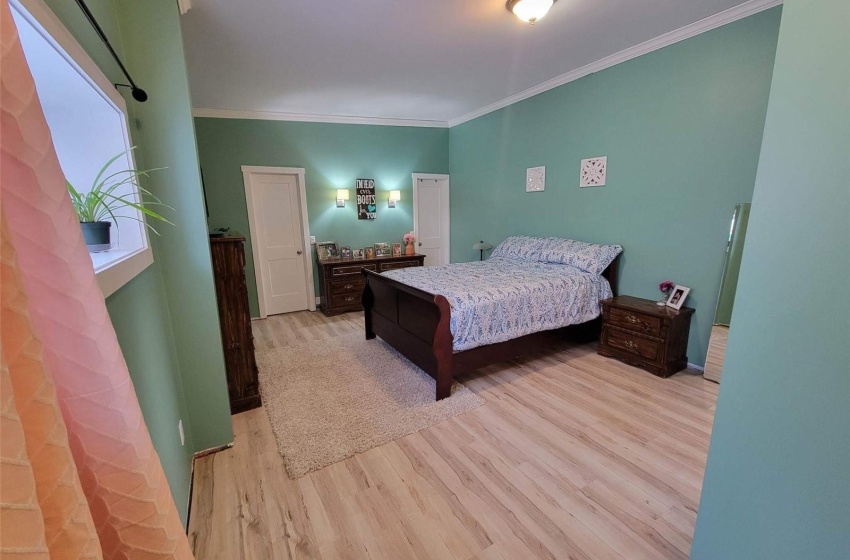 Bedroom with light hardwood / wood-style flooring and crown molding