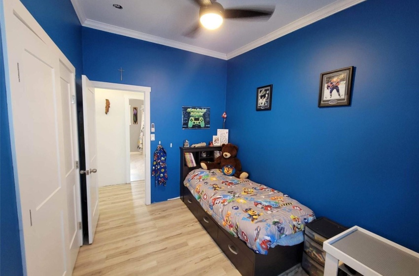 Bedroom featuring ornamental molding, ceiling fan, and light hardwood / wood-style flooring