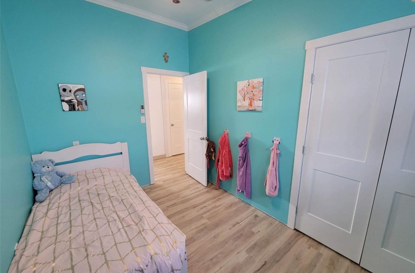 Bedroom with crown molding, ceiling fan, and light wood-type flooring