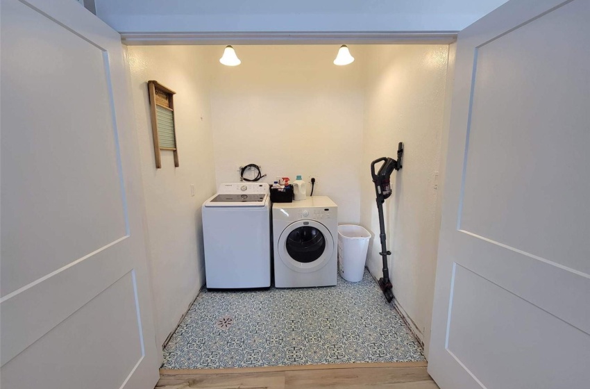 Laundry area featuring light wood-type flooring and washing machine and clothes dryer