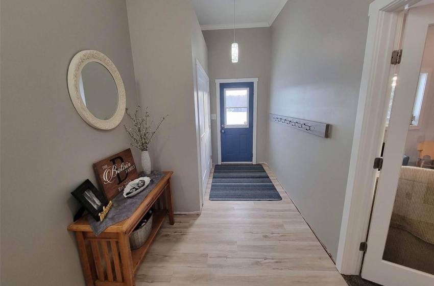 Doorway with ornamental molding and light hardwood / wood-style flooring