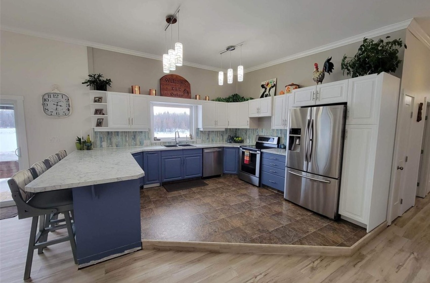 Kitchen with blue cabinets, sink, a kitchen breakfast bar, appliances with stainless steel finishes, and a chandelier