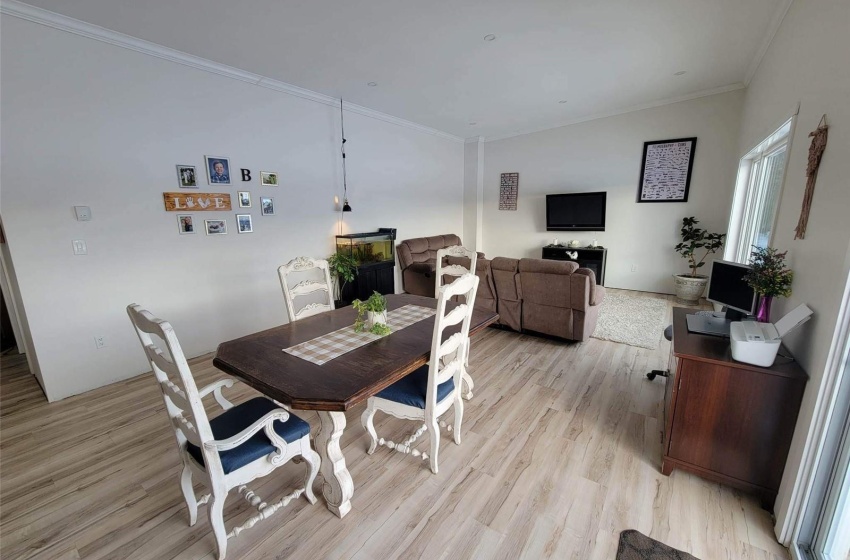 Dining room with crown molding and light hardwood / wood-style flooring