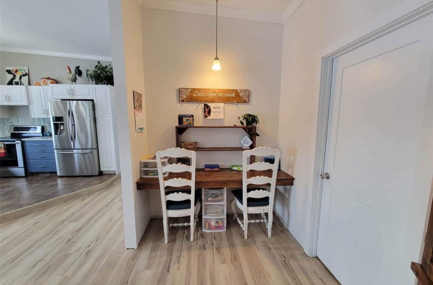 Dining room with ornamental molding and light hardwood / wood-style flooring