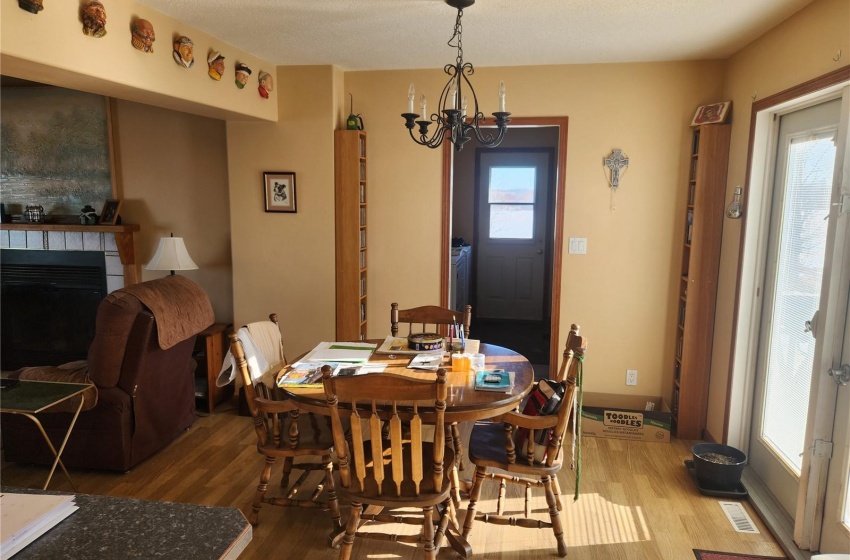 Dining space with a tile fireplace, hardwood / wood-style flooring, a chandelier, and a healthy amount of sunlight