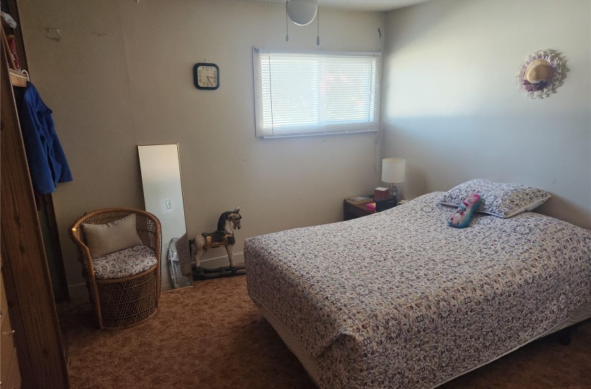 Bedroom with ceiling fan, a textured ceiling, and dark colored carpet