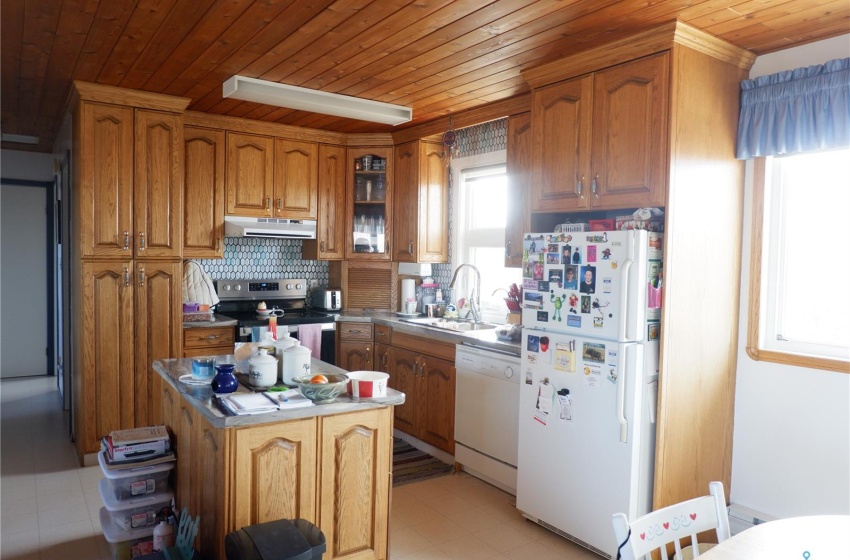 Kitchen with backsplash, white appliances, wood ceiling, and light tile floors