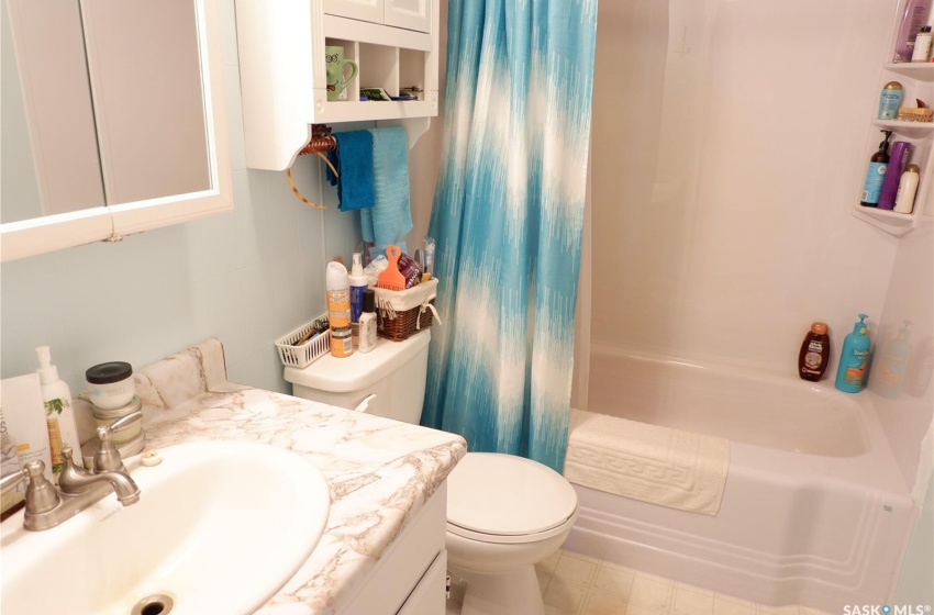 Full bathroom featuring toilet, shower / tub combo, large vanity, and tile flooring