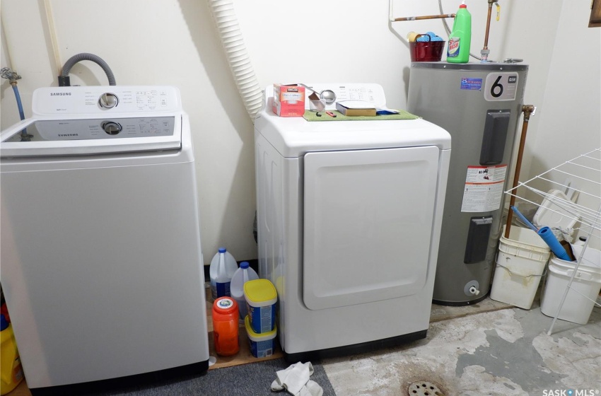 Washroom with washer and clothes dryer and electric water heater