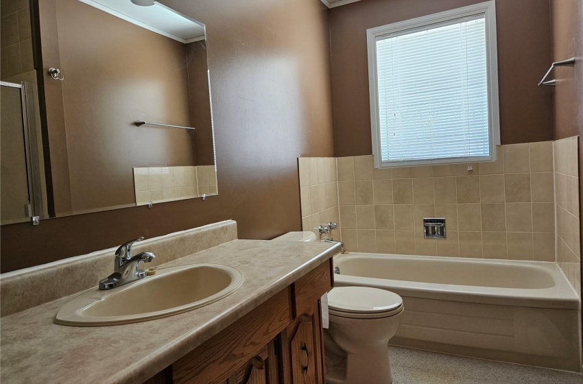 Bathroom featuring toilet, a wealth of natural light, and vanity. Shower on right side