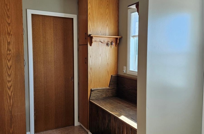 Mudroom just off entrance with doorway to half bath