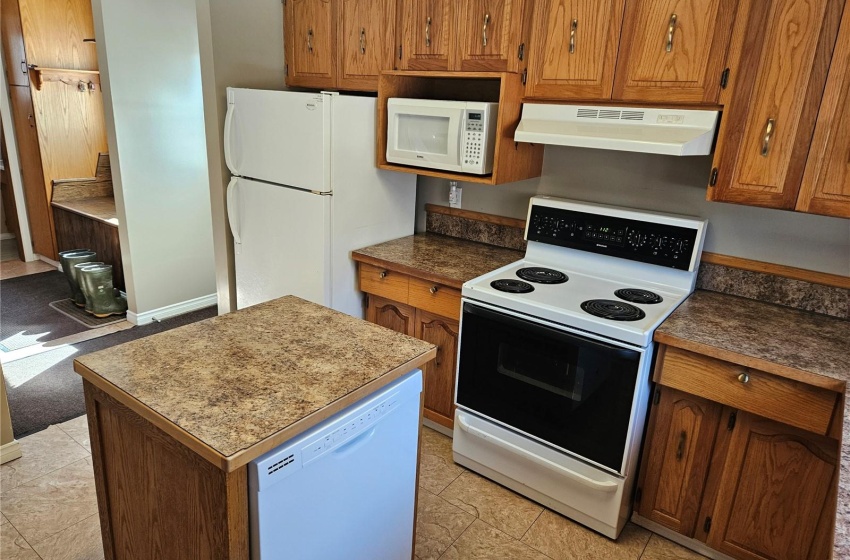 Kitchen with white appliances and light tile floors