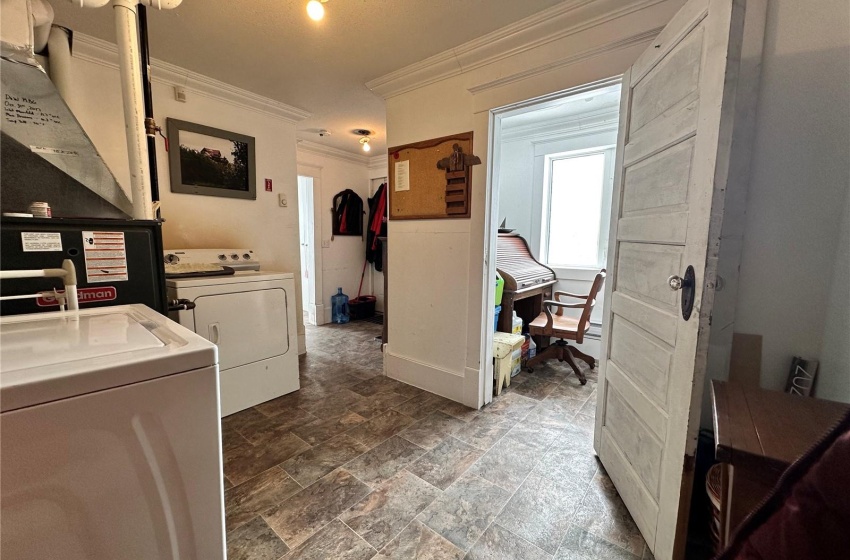 Laundry room featuring dark tile floors, crown molding, and independent washer and dryer