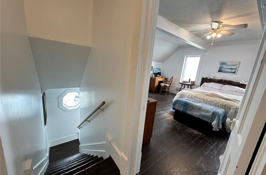 Staircase with dark hardwood / wood-style floors, a textured ceiling, ceiling fan, and lofted ceiling