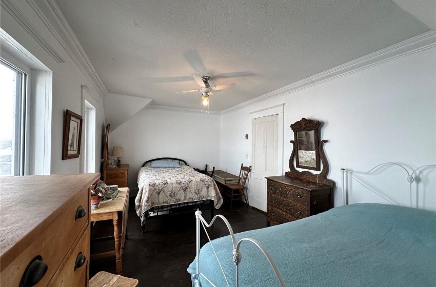 Bedroom featuring crown molding, dark hardwood / wood-style floors, a textured ceiling, and ceiling fan