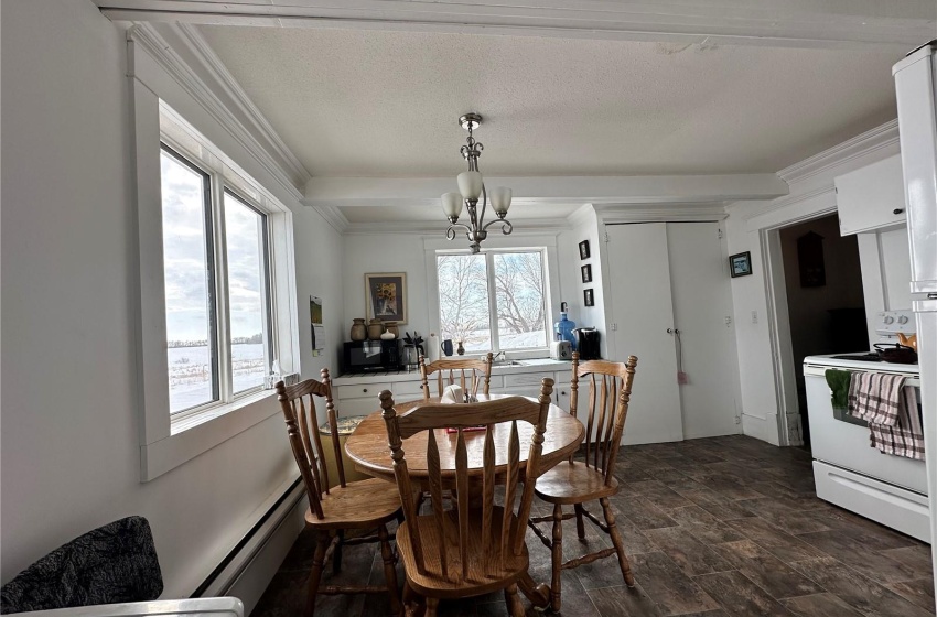 Dining space featuring dark hardwood / wood-style flooring, a notable chandelier, crown molding, and a baseboard heating unit