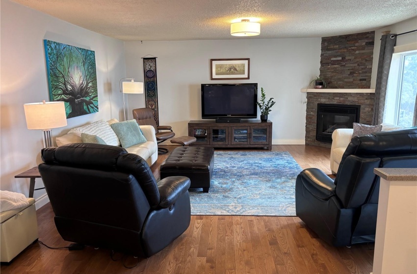 Living room with a stone nat. gas  fireplace and oak flooring