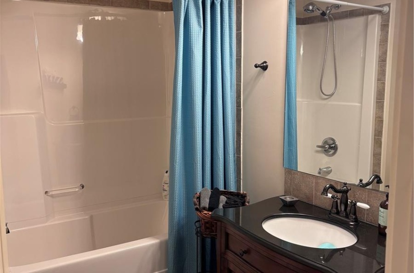 Main floor bathroom featuring vanity, tile flooring, shower / bath combo with shower curtain, and toilet