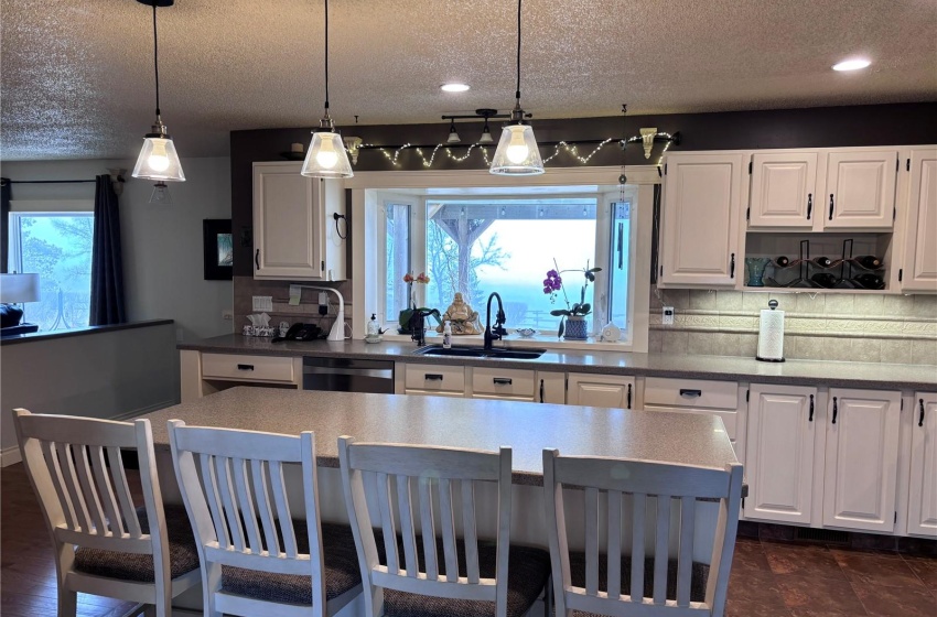 Kitchen with lots of cabinets, plenty of natural light, tasteful backsplash, and dishwasher, tile floor in work area