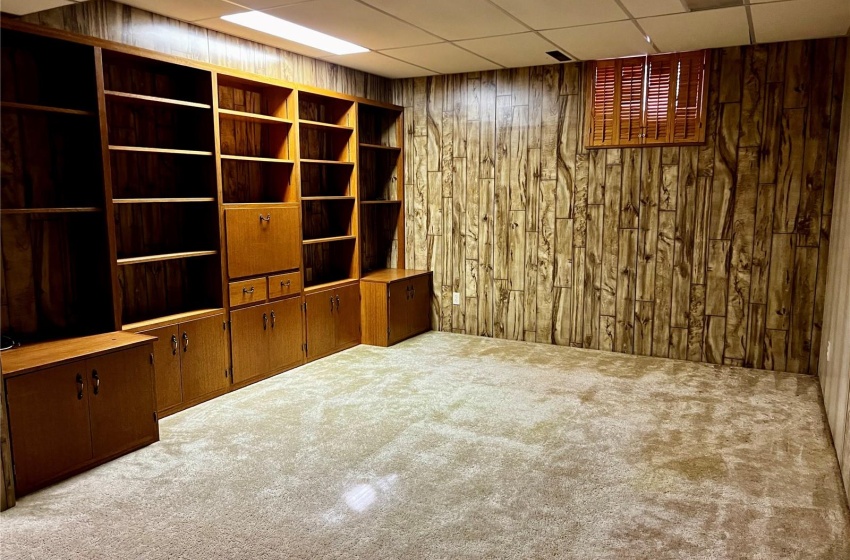 family room complete with built- ins and wiiden shutters on the windows