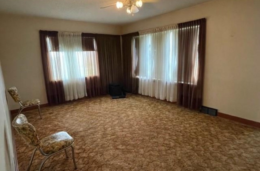 Carpeted living room featuring a textured ceiling and ceiling fan