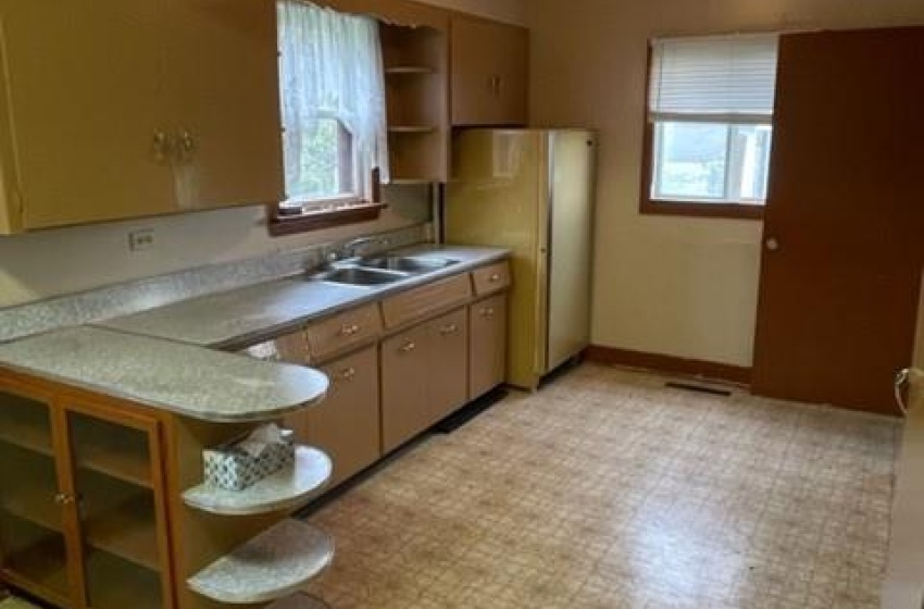 Kitchen featuring plenty of natural light, fridge, light tile floors, and sink