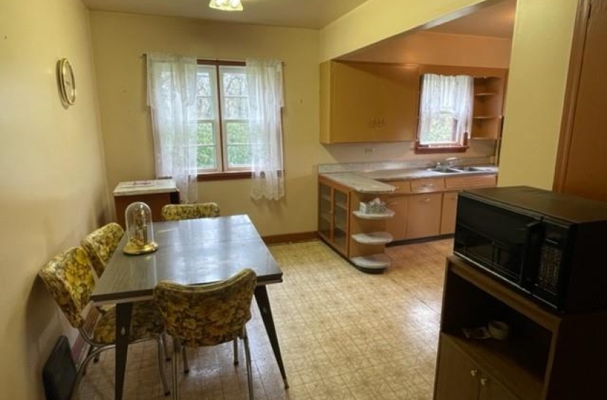 Kitchen with light tile floors, sink, and a wealth of natural light