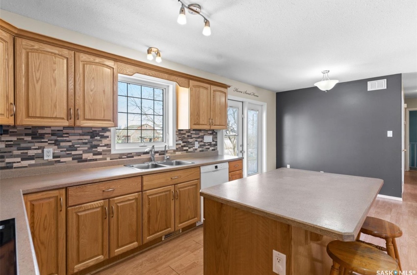 Kitchen featuring light hardwood / wood-style flooring, sink, a kitchen bar, and a healthy amount of sunlight