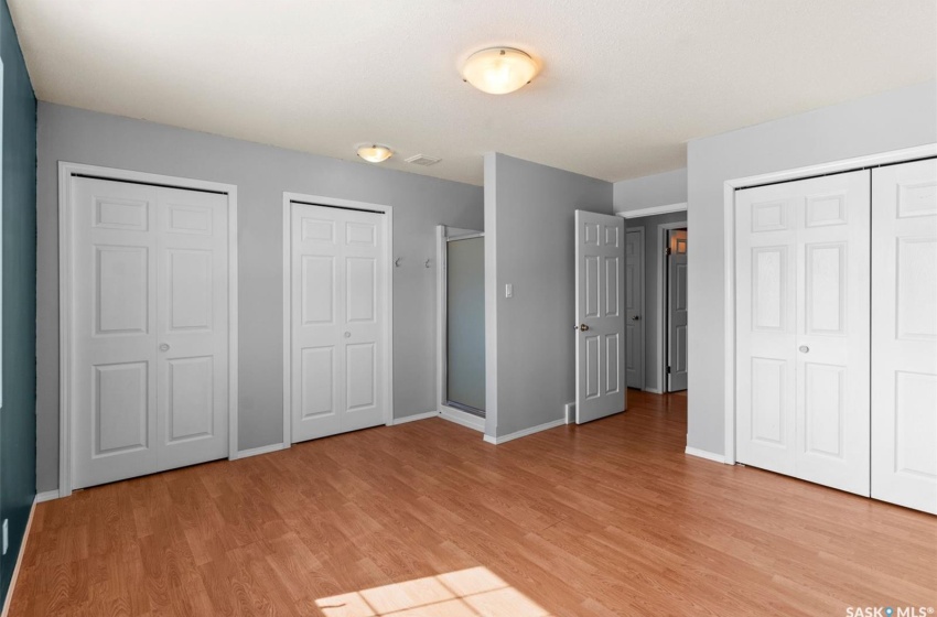 Unfurnished bedroom with multiple closets and light hardwood / wood-style floors