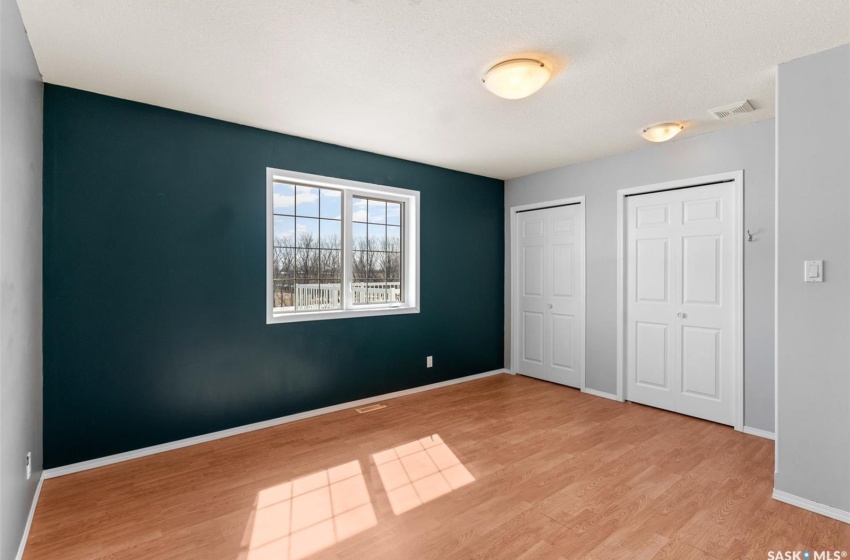 Unfurnished bedroom with multiple closets and light wood-type flooring