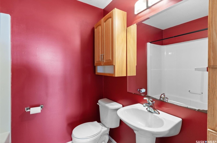 Full bathroom featuring toilet, washtub / shower combination, and sink