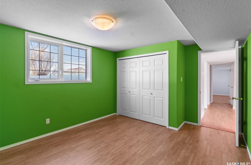 Unfurnished bedroom featuring a closet, a textured ceiling, and light hardwood / wood-style flooring