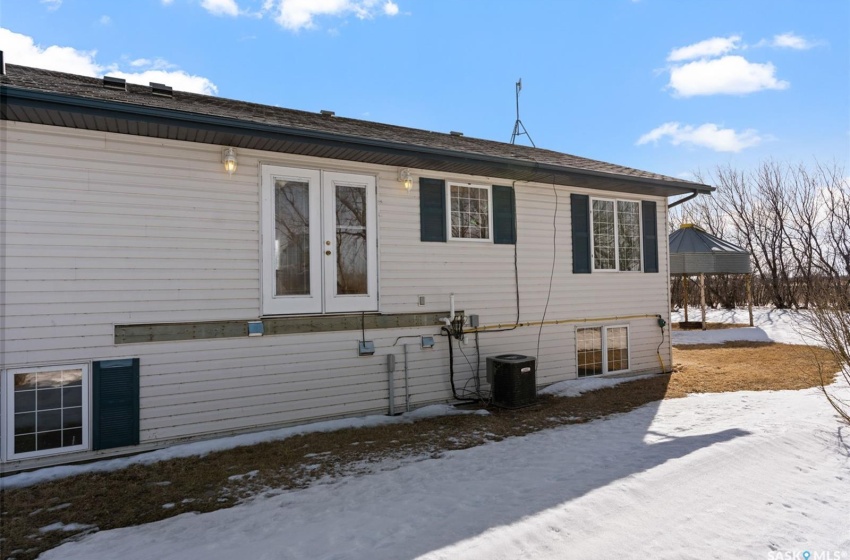 View of snow covered exterior featuring french doors and central AC unit