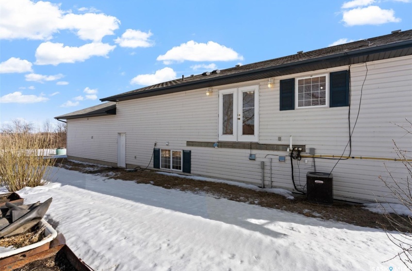 Snow covered back of property featuring central AC unit