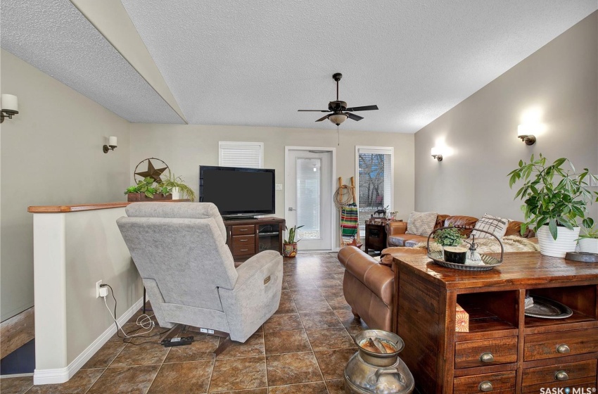 Living room with dark tile floors, a textured ceiling, and ceiling fan