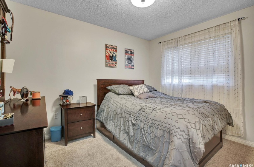 Bedroom featuring light colored carpet and a textured ceiling