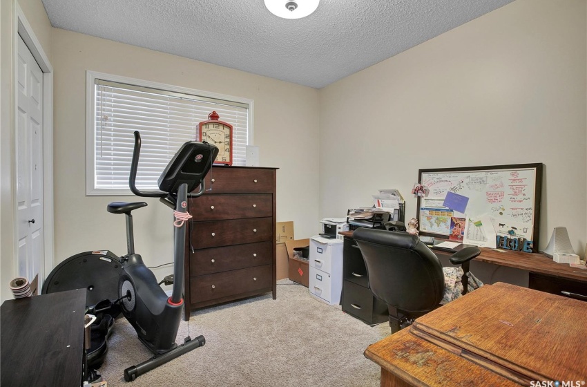 Office space featuring light colored carpet and a textured ceiling