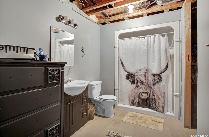 Bathroom featuring toilet, vanity with extensive cabinet space, and concrete flooring