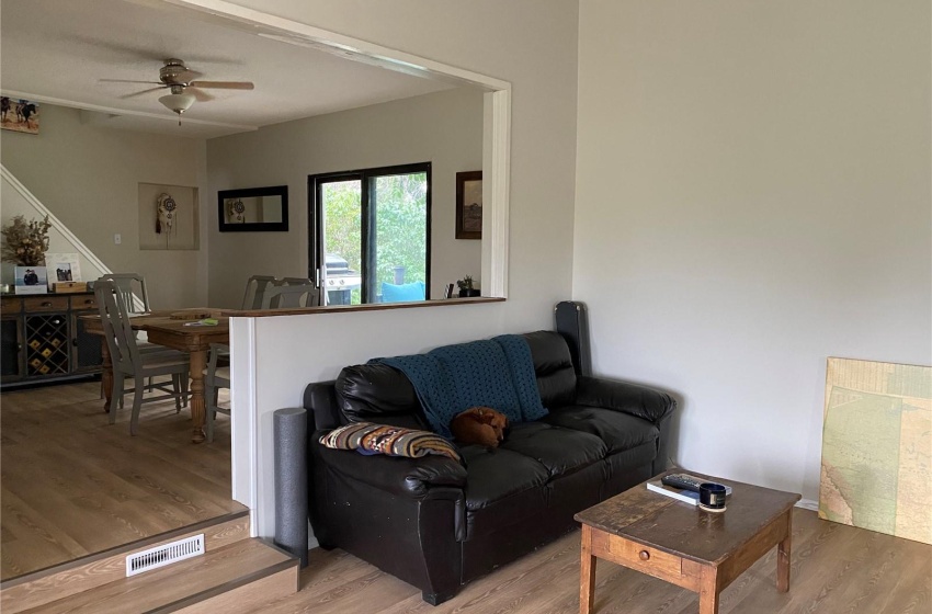 Living room with light hardwood / wood-style floors and ceiling fan