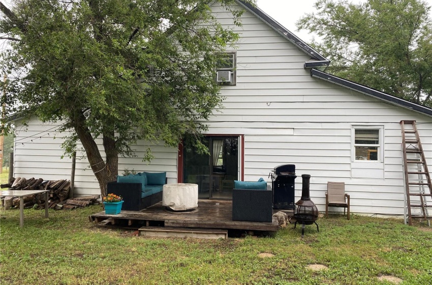 Back of property with a yard and a wooden deck