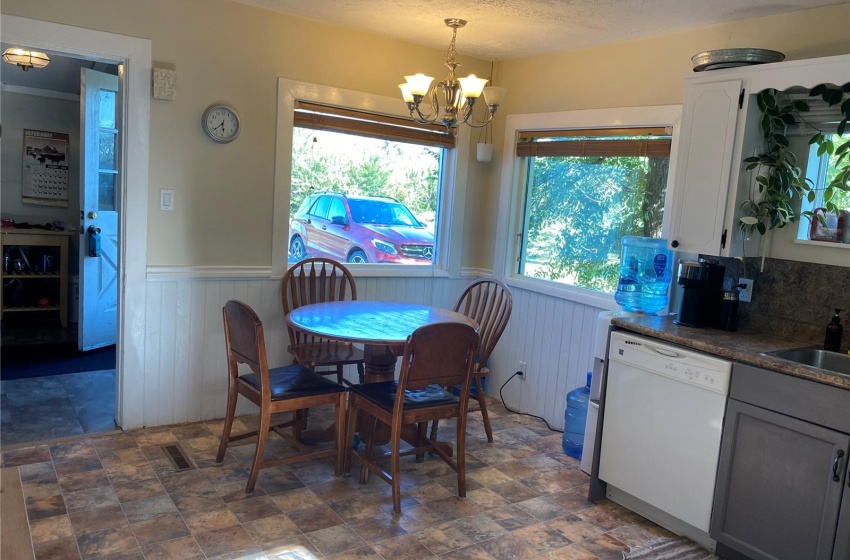 Kitchen with nook, featuring sink, a textured ceiling, a notable chandelier, and a healthy amount of sunlight