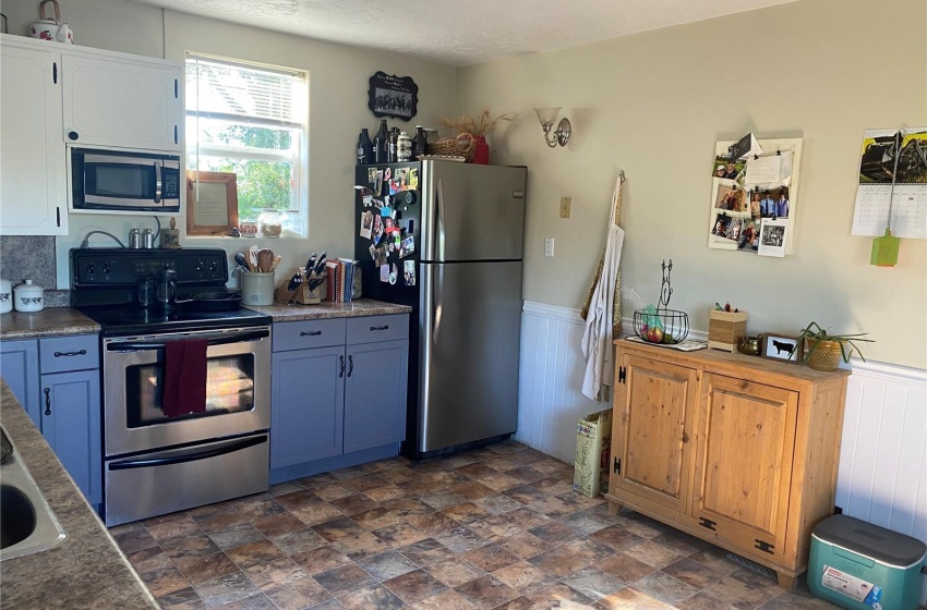 Kitchen with appliances with stainless steel finishes, blue and white cabinetry