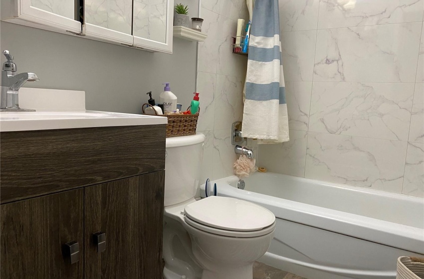 Full bathroom featuring vanity, tiled shower / bath combo, and toilet